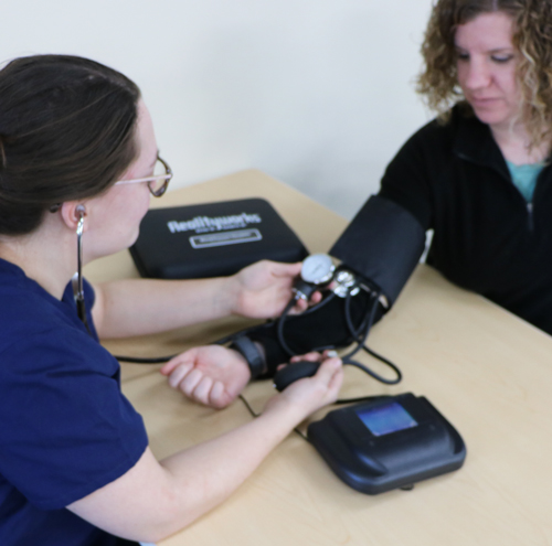 Students using Realityworks' blood pressure simulator
