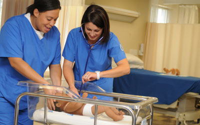 Nursing students practicing with infant simulators
