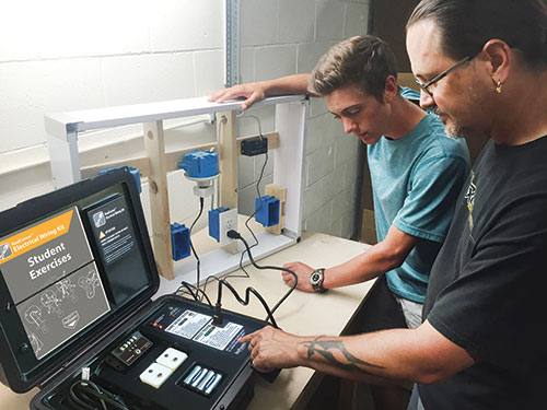 Instructor showing student electrical kit