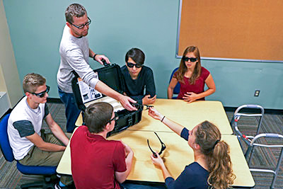 Teacher and students using the geriatric simulator
