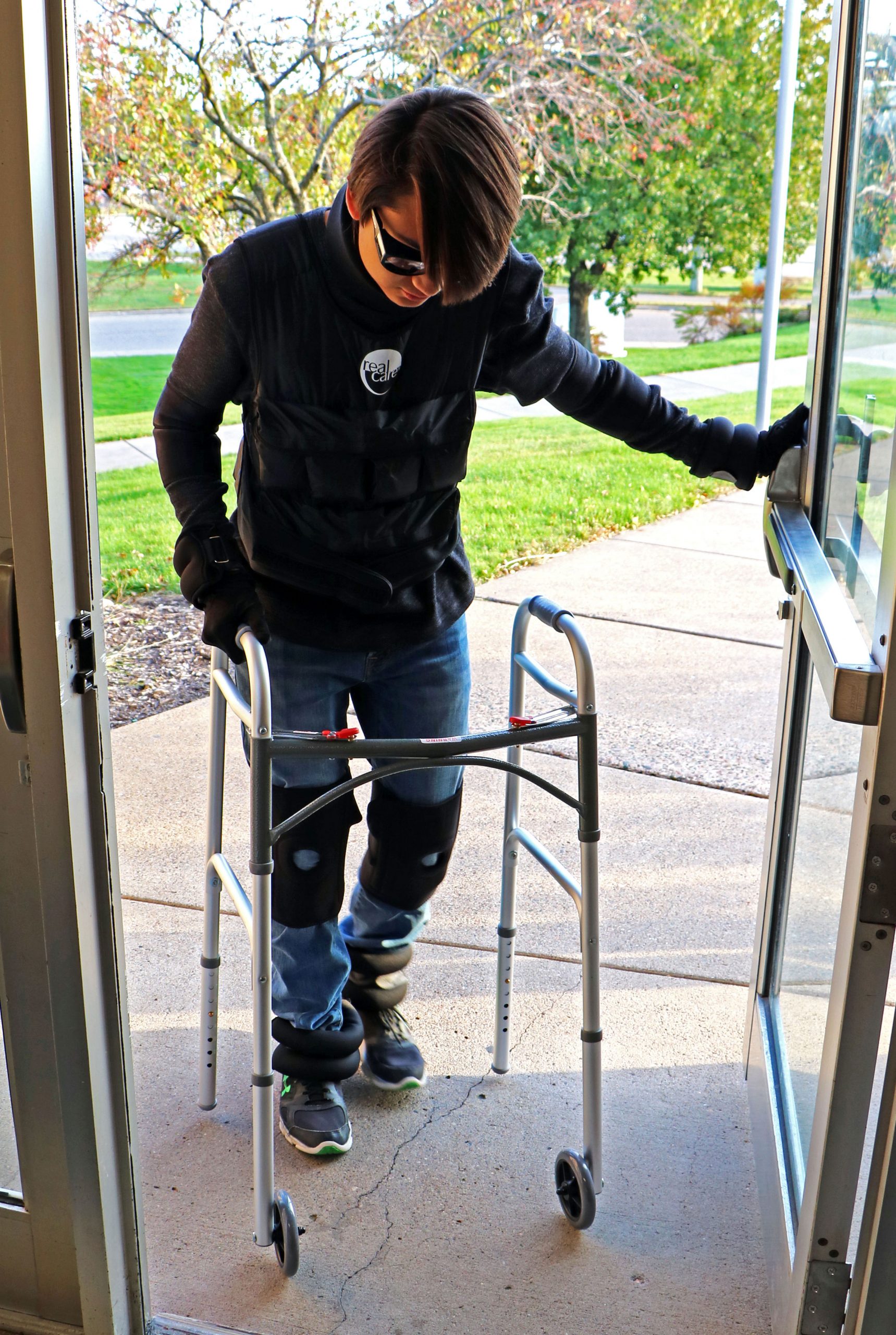 Person opening door in Geriatric Simulator sensitivity suit