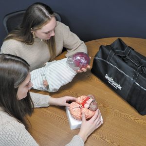 Students examining a Shaken Baby Simulator