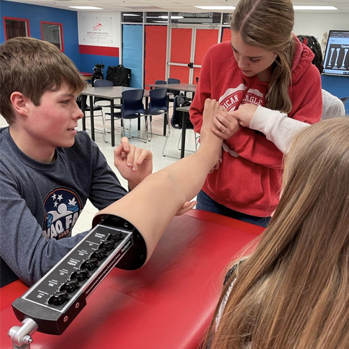 Students using Realityworks' Knee and Ankle Sports Injury Assessment Trainer