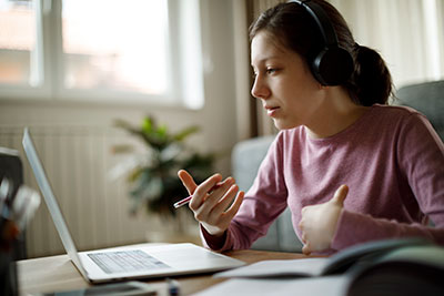 Student listening and taking notes on a virtual lecture