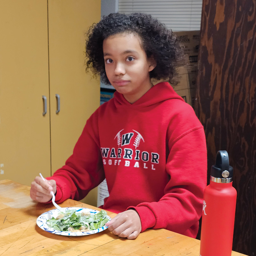 Student eats a salad from the hydroponics system