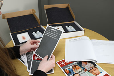 Student holding scenario card with child abuse and neglect kit
